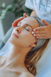 Woman receiving a traditional Spanish facial massage with relaxing hand techniques applied to the temples.